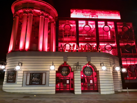 An external photograph of The Alhambra Theatre lit up in red